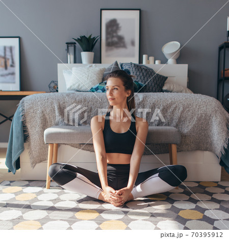 young-woman-stretches-her-legs-with-her-knees-70395912-pixta