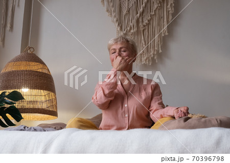 Senior woman practicing yoga at home, making Alternate Nostril Breathing exercise, nadi shodhana pranayama Senior woman practicing yoga at home, making Alternate Nostril Breathing exercise, nadi shodhana pranayama 70396798