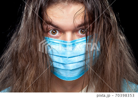 male portrait in a medical mask with a negatively surprising excited expression and disheveled hair on his head, close up. 70398353