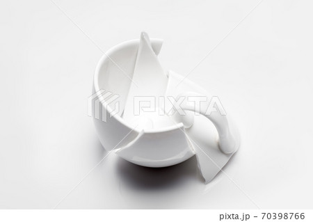 broken white ceramic tea cup on a white background, conceptual photo with a shattered object. 70398766