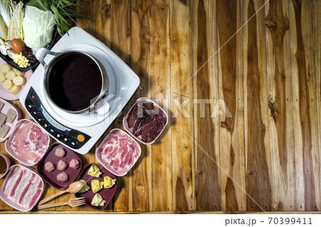 Thai style hot pot with delicious food ingredient on wood background and space for text Thai style hot pot with delicious food ingredient on wood background and space for text 70399411
