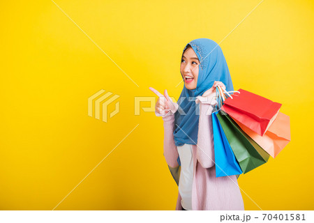 Asian Muslim Arab woman Islam wear hijab smile she holding colorful shopping bags Asian Muslim Arab woman Islam wear hijab smile she holding colorful shopping bags 70401581