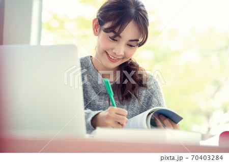 ノートPCとテキストを勉強している女子大生 70403284