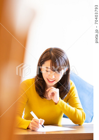 ボールペンで書く女性 70403793