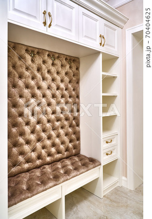 Classic white wardrobe with seating and shelves in contemporary bright hallway. Carriage coupler closet bench Classic white wardrobe with seating and shelves in contemporary bright hallway. Carriage coupler closet bench 70404625