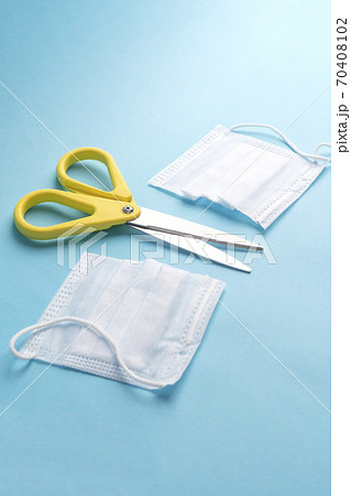 Cut medical protective mask and yellow scissors on a blue paper background. The concept of disposable protection against coronavirus Cut medical protective mask and yellow scissors on a blue paper background. The concept of disposable protection against coronavirus 70408102
