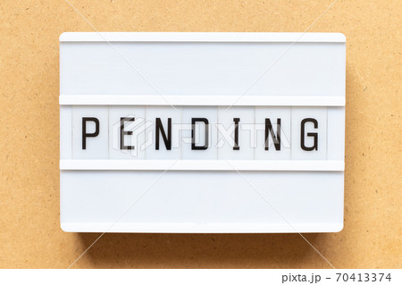 Lightbox with word pending on wood background 70413374