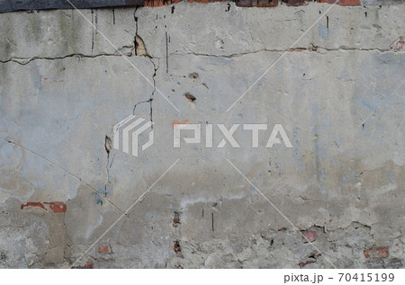 old grey concrete garage wall with red bricks and cracks abstract background 70415199