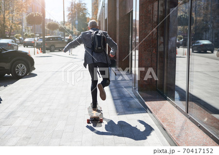 Active senior citizen travelling on his longbaord 70417152