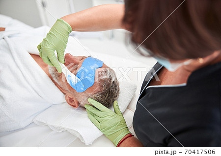 Professional spa therapist doing skincare procedures for a customer 70417506