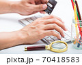 Person entering number of credit card with white 70418583
