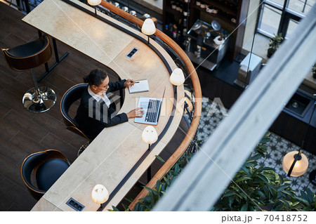 Attentive brunette female staring at screen of laptop Attentive brunette female staring at screen of laptop 70418752