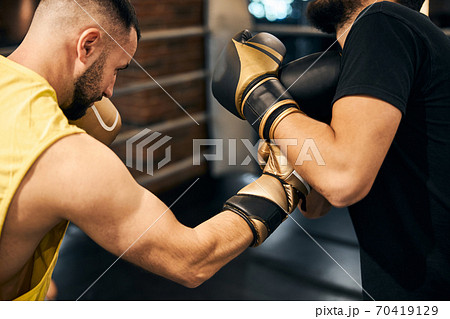 Male boxer attacking opponent with a right hook 70419129