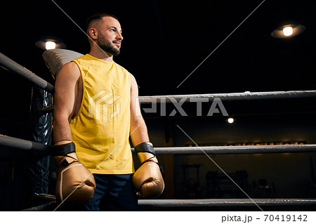 Smiling boxer standing in a corner of the ring 70419142