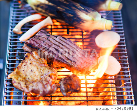バーベキューで炭火でビーフステーキを焼く　【アウトドアの醍醐味】 70420991