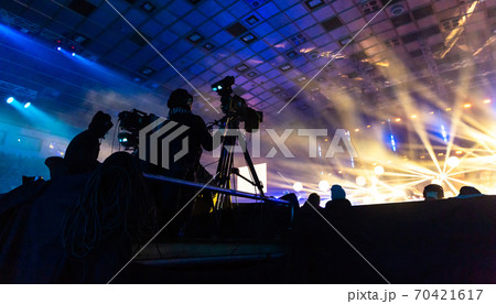 Television broadcast by a cameraman during a concert. Camera with the operator is on the high platform. 70421617