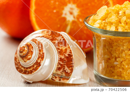 Cut orange, sea shall and glass bowl with yellow sea salt 70422506