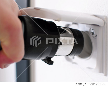 Plugging central vacuum cleaner in to wall inlet 70423890