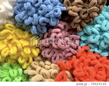 Colorful tangles tangles of plush yarn for hand knitting with ready loops. The background polyester curly threads. 70424139