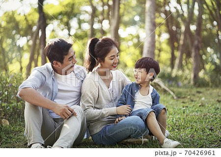 young asian family with parents and son having fun outdoors in park 70426961
