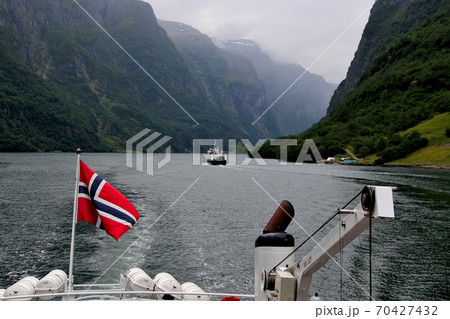 ノルウェー　フロム～グドヴァンゲン間のソグネフィヨルド・クルーズの観光船の船尾にノルウェー国旗。 70427432