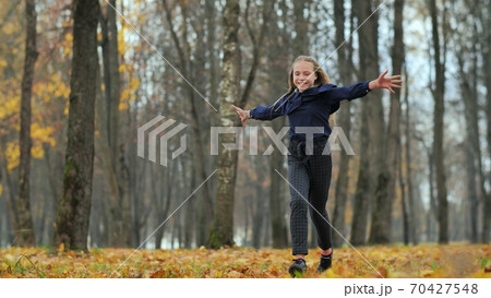 Happy teenage girl runs in the autumn park. Happy teenage girl runs in the autumn park. 70427548