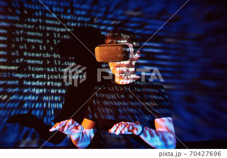 Double exposure of a caucasian man and Virtual reality headset is presumably a gamer or a hacker cracking the code into a secure network or server, with lines of code 70427696