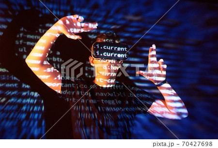 Double exposure of a caucasian man and Virtual reality headset is presumably a gamer or a hacker cracking the code into a secure network or server, with lines of code 70427698