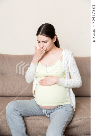 Pregnancy Morning Sickness. Pregnant Woman Having Nausea Feeling Bad in Sofa at the Home Pregnancy Morning Sickness. Pregnant Woman Having Nausea Feeling Bad in Sofa at the Home 70427831