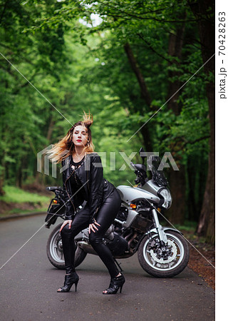 An attractive sexy girl on a sports motorbike posing outside An attractive sexy girl on a sports motorbike posing outside 70428263