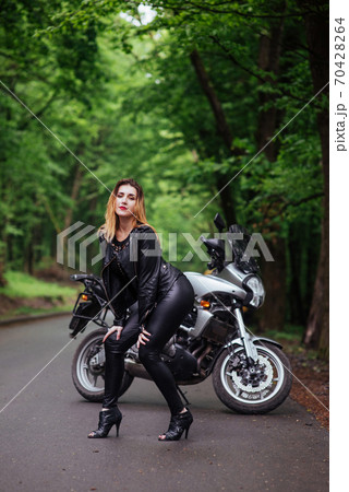 An attractive sexy girl on a sports motorbike posing outside An attractive sexy girl on a sports motorbike posing outside 70428264