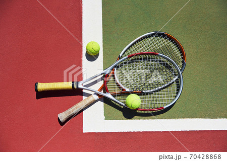 A tennis racket and new tennis ball on a freshly painted tennis court 70428868