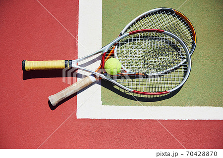 A tennis racket and new tennis ball on a freshly painted tennis court 70428870