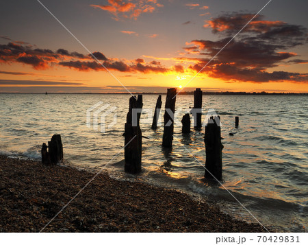 Remains of old wooden jetty looking to Harwich with stunning sunset, Felixstowe Remains of old wooden jetty looking to Harwich with stunning sunset, Felixstowe 70429831