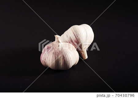 2 fresh garlic bulbs on a black background. 70430796