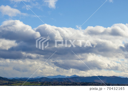 Mountain range in clear weather in contrasting rain clouds before the rain. Beautiful picturesque landscape Mountain range in clear weather in contrasting rain clouds before the rain. Beautiful picturesque landscape 70432165