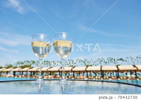 Glasses of champagne at a resort pool in a luxury hotel. Party by the pool. Pouring drink in a glass. Amara Dolce Vita Luxury Hotel. Resort. Tekirova-Kemer Glasses of champagne at a resort pool in a luxury hotel. Party by the pool. Pouring drink in a glass. Amara Dolce Vita Luxury Hotel. Resort. Tekirova-Kemer 70432730