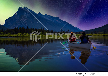 Couple adventurous friends are canoeing in a lake Couple adventurous friends are canoeing in a lake 70433659