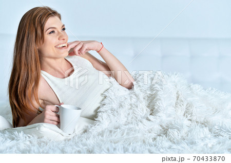 Beautiful young woman with cup of coffee 70433870