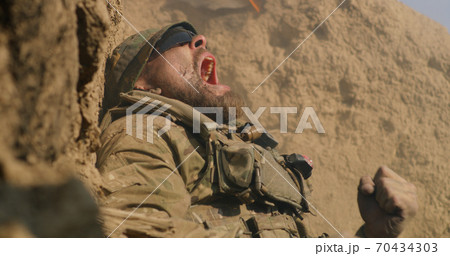 Scared fighter hiding in trench during war Scared fighter hiding in trench during war 70434303
