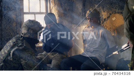 Male soldier interrogating young prisoners Male soldier interrogating young prisoners 70434316