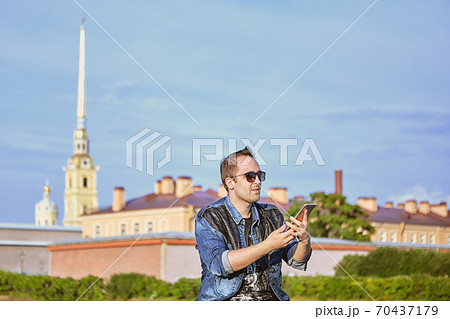 Tourist takes pictures of landmarks using a smartphone, St. Petersburg, Russia. Tourist takes pictures of landmarks using a smartphone, St. Petersburg, Russia. 70437179