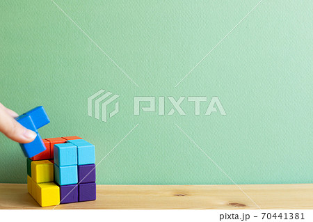 Colorful cube puzzle blocks on wooden desk with green background. Problem solving, creative idea concept Colorful cube puzzle blocks on wooden desk with green background. Problem solving, creative idea concept 70441381