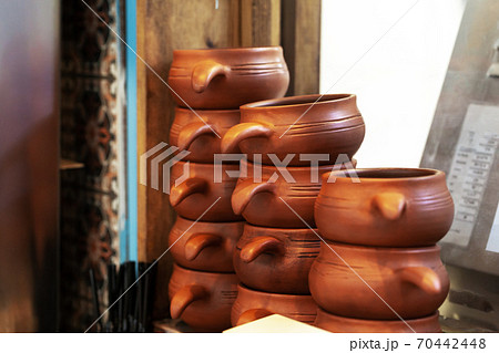 Clay pots on a wooden shelf close up Clay pots on a wooden shelf close up 70442448