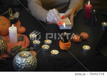 Blurred hand with matchstick, lighting a Candle. Halloween esoteric Blurred hand with matchstick, lighting a Candle. Halloween esoteric 70442758