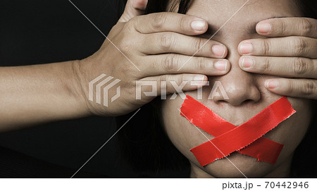 Asian woman blindfold wrapping mouth with red adhesive tape Asian woman blindfold wrapping mouth with red adhesive tape 70442946