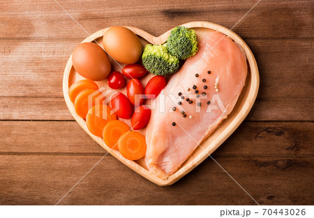 Raw chicken breasts fillets in heart plate wood Raw chicken breasts fillets in heart plate wood 70443026