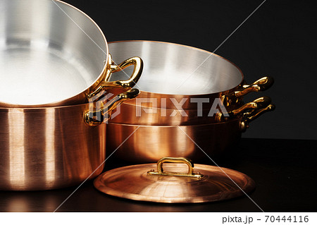 Set of copper cookware over dark background Set of copper cookware over dark background 70444116