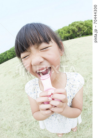 ゴム風船を膨らます女の子の写真素材 ゴム風船を膨らます女の子の写真素材