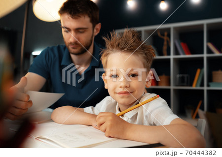 Dad and son doing school homework together 70444382